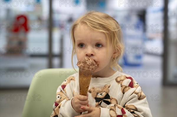 Interior shot, girl, 2-3 years, blonde, eating chocolate ice cream, ice cream, waffle, mouth