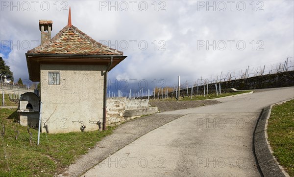 Steep path and historic small house with square floor plan, red roof and chimney in the UNESCO
