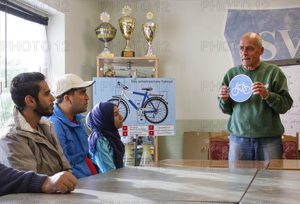 Syrian refugees learn traffic rules during an integration course. An employee of the