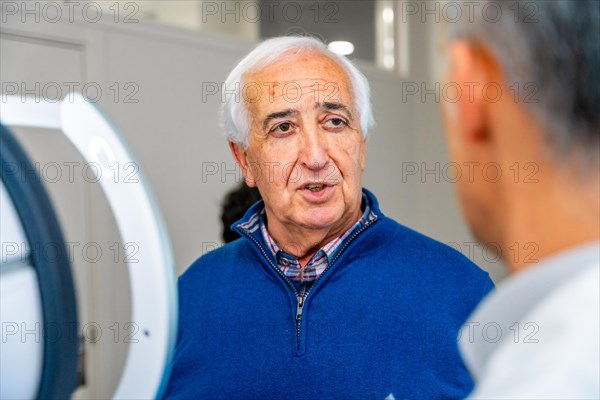 Satisfied senior man talking to an ophthalmologist in the clinic after receive an innovative