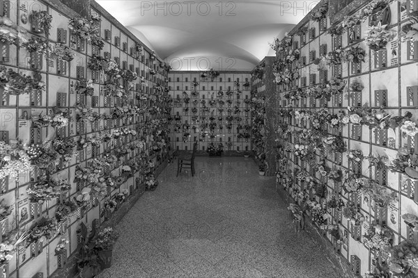 Graves with floral decorations in a hall at the Monumental Cemetery, Cimitero monumentale di