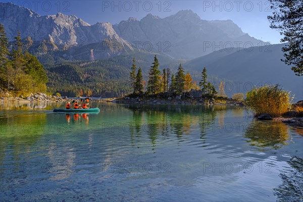 Canoeists on a mountain lake in front of steep mountains, reflection, evening light, autumn, Eibsee