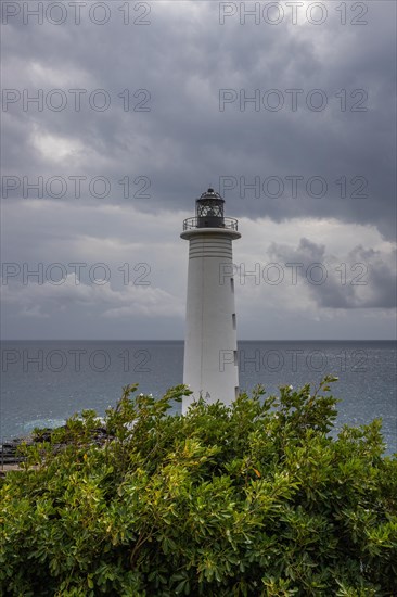 Le Phare du Vieux-Fort, white lighthouse on a cliff. Dramatic clouds with a view of the sea. Pure