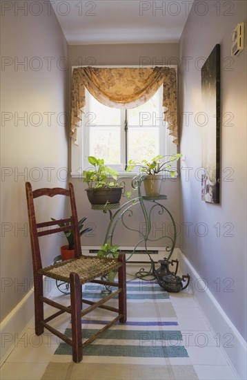 Antique wooden weaved seat chair and ornamental Penny-Farthing bicycle support stand for planters