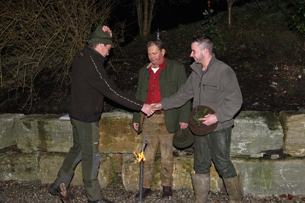 Wild boar (Sus scrofa) Hunting guide presents hunter with a gun after the hunt, tradition, Allgaeu,