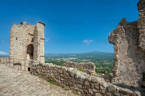 Ruins of Grimaud Castle with a view of the village of Grimaud, in the background the hills of the