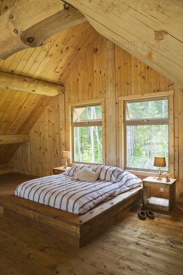 King size bed with wooden frame in master bedroom on upstairs floor inside handcrafted Eastern