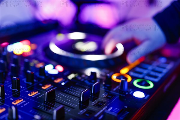 Hand of a DJ on a mixing desk, also called DJ controller or DJ console, at a party, Cologne, North