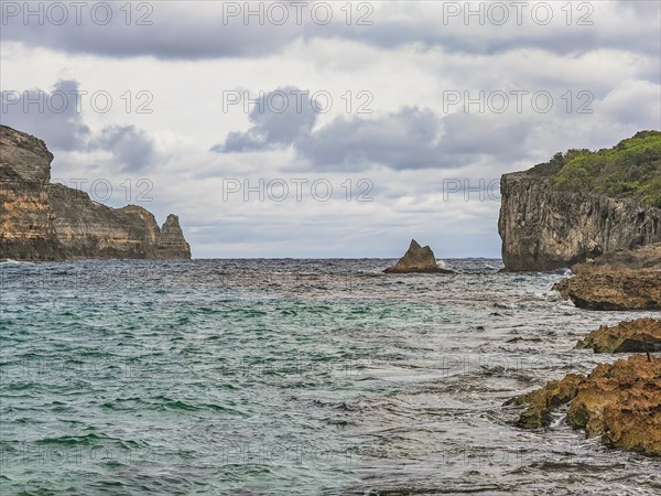 Rocky coast, long bay by the sea at sunset. Dangerous view of the Caribbean Sea. Tropical climate