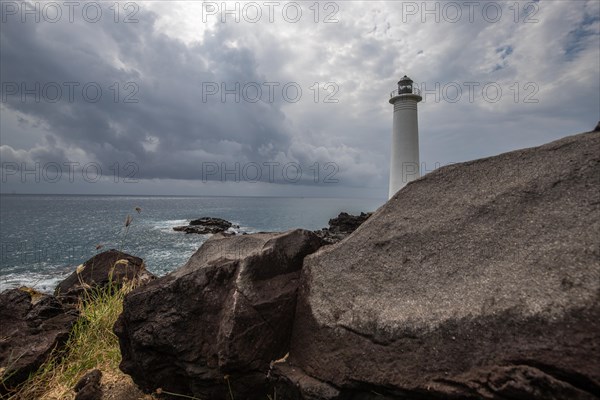 Le Phare du Vieux-Fort, white lighthouse on a cliff. Dramatic clouds with a view of the sea. Pure