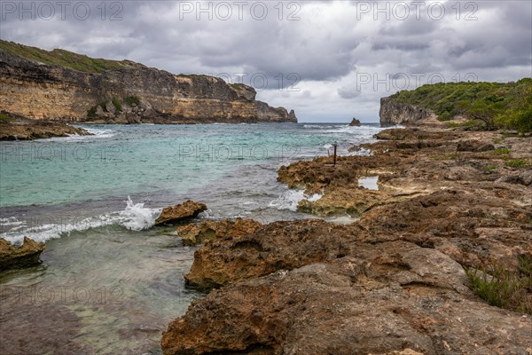 Rocky coast, long bay by the sea at sunset. Dangerous view of the Caribbean Sea. Tropical climate