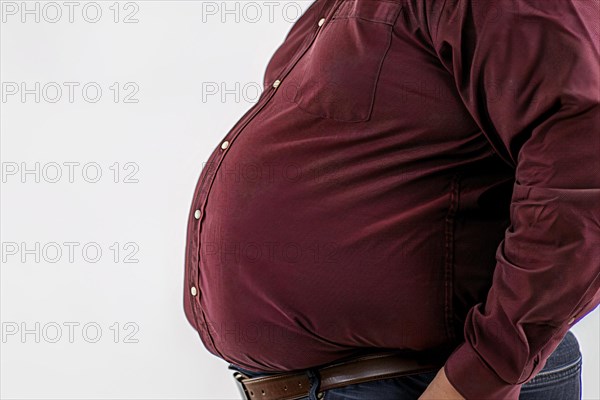 Close up of fat belly of heavily obese man in red shirt on white background. KI generiert,