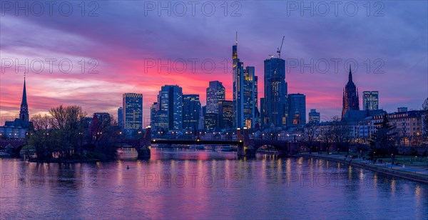 The Frankfurt skyline with office tower blocks behind the Main at sunset, on the left the