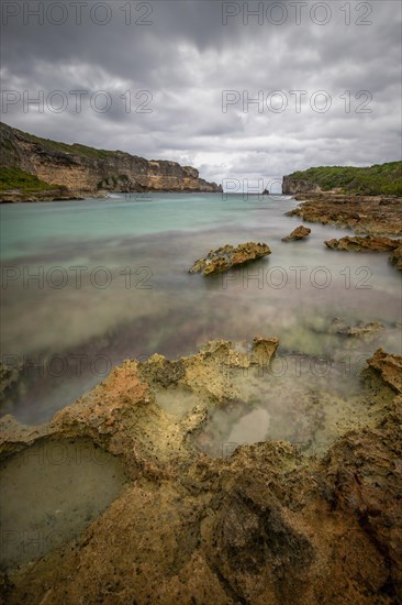 Rocky coast, long bay by the sea at sunset. Dangerous view of the Caribbean Sea. Tropical climate