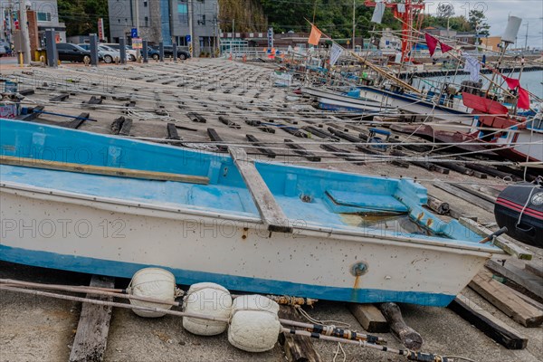 Fishing boats in dry dock with ropes and buoys, awaiting the return to water, in Ulsan, South