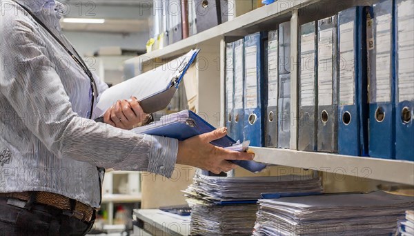 A woman works efficiently in the archive sorting files and paperwork, symbolism bureaucracy, AI