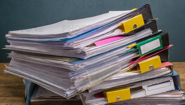 Colourful labels and clips on piles of files stand for order and office organisation, symbol