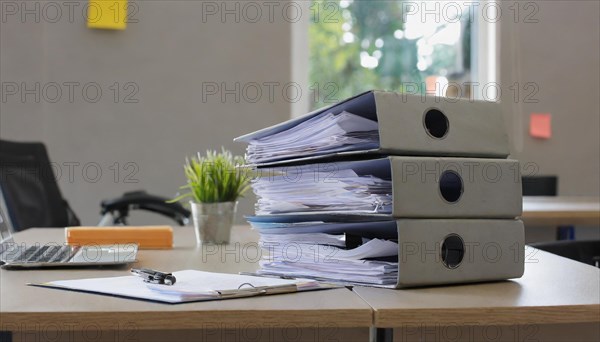 Black folders on a desk next to a laptop and a small plant, symbolising bureaucracy, AI generated,