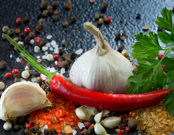 Fresh garlic arranged with red chilli, colourful peppercorns and green herbs, AI generated, AI