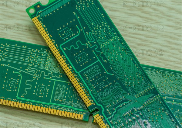 Several RAM modules placed together showcasing their gold contacts and green circuitry, in South
