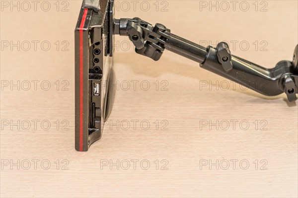 Side view of automobile navigation system with attached mounting arm showing the various IO ports