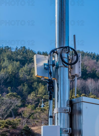 Closeup of coaxial cables from outdoor wireless router secured to meal pole using electrical tape
