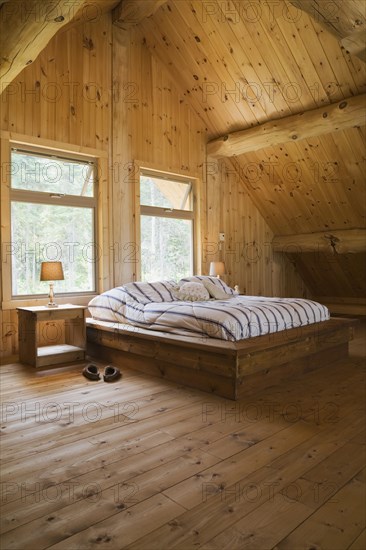 King size bed with wooden frame in master bedroom on upstairs floor inside handcrafted Eastern
