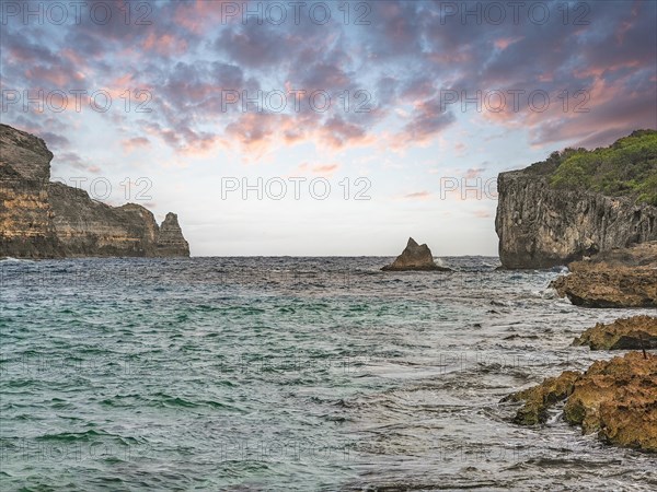 Rocky coast, long bay by the sea at sunset. Dangerous view of the Caribbean Sea. Tropical climate