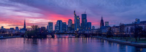The Frankfurt skyline with office tower blocks behind the Main at sunset, on the left the