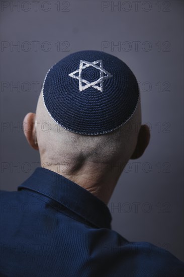 Jewish man wearing a kippa with a Star of David on his head, back view, studio shot, Germany,