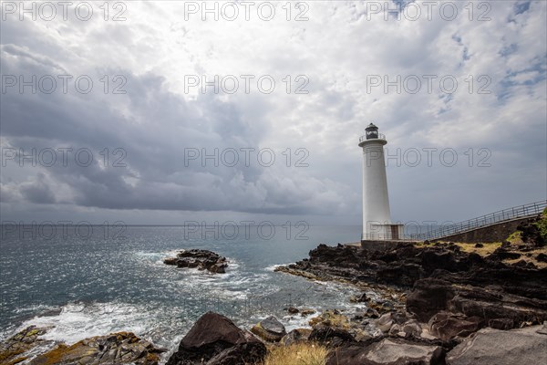 Le Phare du Vieux-Fort, white lighthouse on a cliff. Dramatic clouds with a view of the sea. Pure