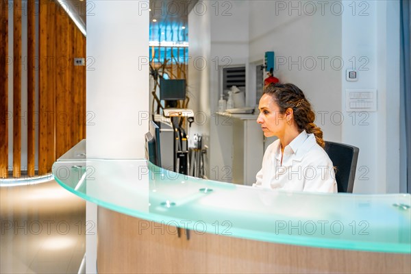 Side view photo with copy space of a female healthcare worker in the reception of an ophthalmology