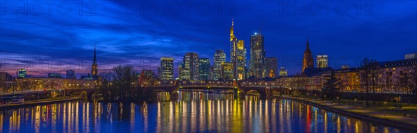 The Frankfurt skyline with office tower blocks behind the Main at blue hour after sunset, on the