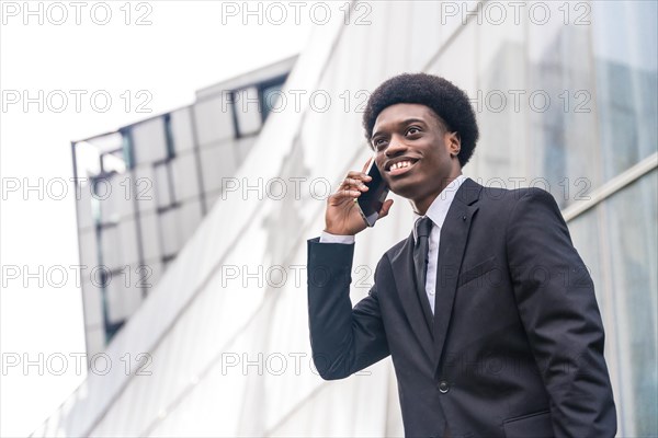 Low angle view close-up portrait with copy space of a Young african businessman using phone in the