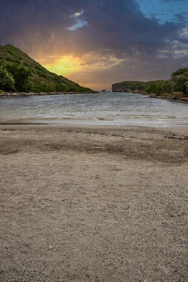 Rocky coast, long bay by the sea at sunset. Dangerous view of the Caribbean Sea. Tropical climate