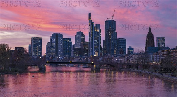 The Frankfurt skyline with office towers behind the Main at sunset, on the right the Kaiserdom,