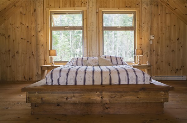 King size bed with wooden frame in master bedroom on upstairs floor inside handcrafted Eastern