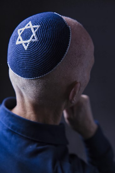 Jewish man wearing a kippa with a Star of David on his head, back view, studio shot, Germany,