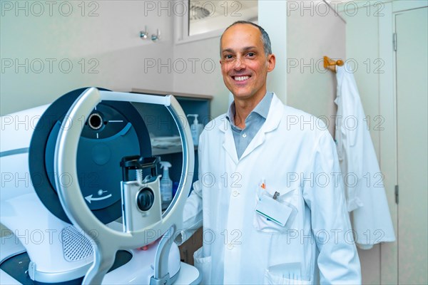 Portrait of an ophthalmologist in an innovative clinic standing next to a laser machine to treat