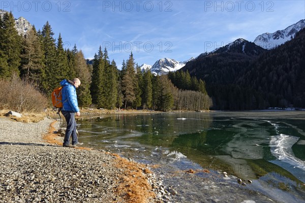 Hikers in winter on an icy lake, Lake Antholz in the Antholz Valley, Val Pusteria, South Tyrol,