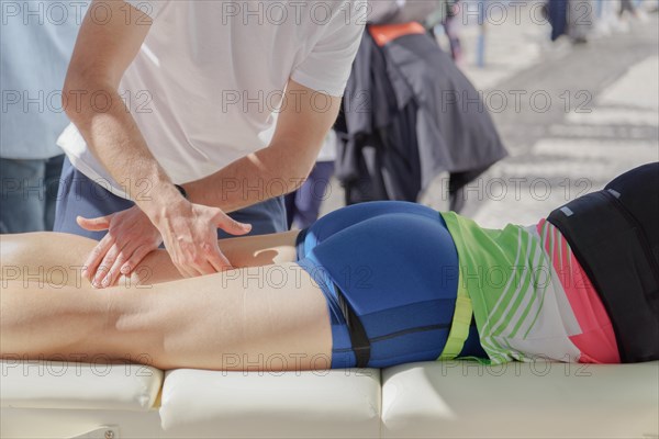 A first responder is administering first aid to a marathon runner who has collapsed on the ground.