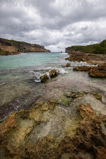 Rocky coast, long bay by the sea at sunset. Dangerous view of the Caribbean Sea. Tropical climate