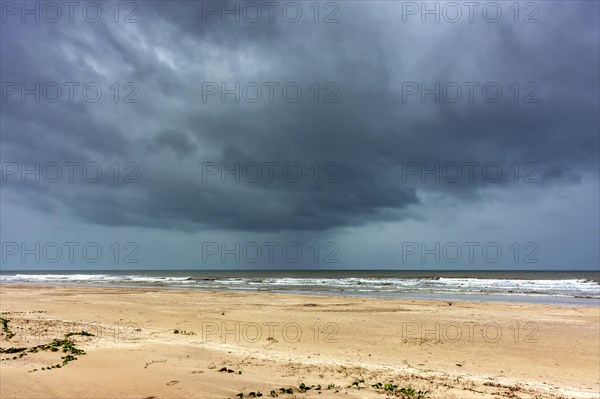 Dark rain clouds over the sea at Sargi beach in Serra Grande on the coast of Bahia, Bahia, Brazil,