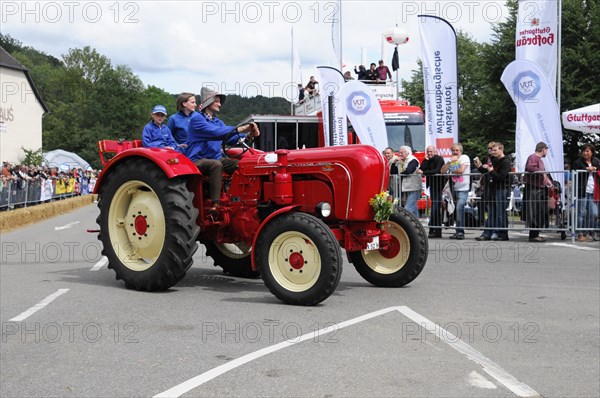 Porsche Diesel Tractors, A historic red tractor is proudly driven in a summer parade, SOLITUDE
