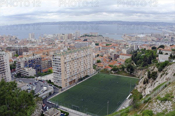 Marseille, panoramic view of a city with harbour, football pitch and high-rise buildings by the