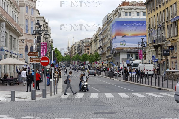 Marseille, A busy city street with people crossing the road and urban architecture, Marseille,