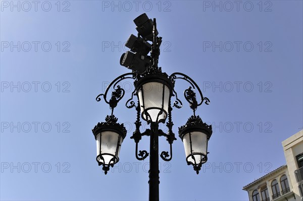 Granada, An ornate wrought iron street lamp against a clear blue sky, Granada, Andalusia, Spain,