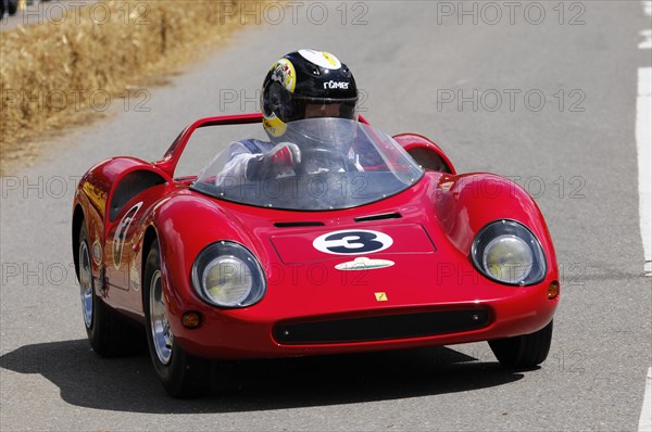 Intensely focussed driver in a bright red soapbox at high speed, SOLITUDE REVIVAL 2011, Stuttgart,
