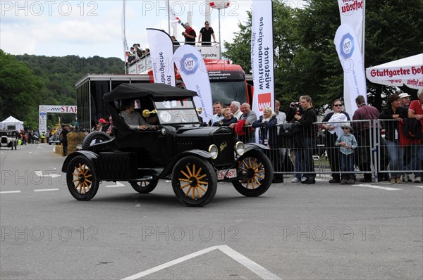 A black Ford Model T vintage car drives in front of spectators at a historic car race, SOLITUDE