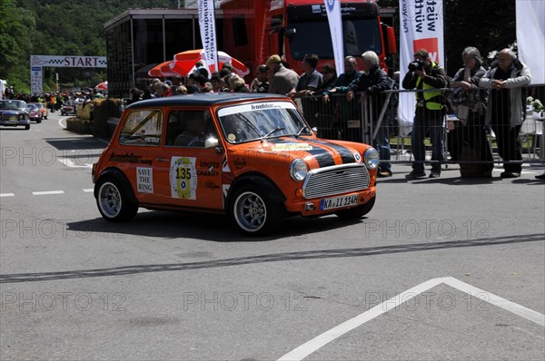 An orange and black Mini Cooper starts on a rally surrounded by spectators, SOLITUDE REVIVAL 2011,